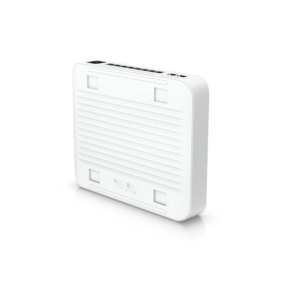 Vista trasera del switch blanco con rejillas de ventilación horizontales y ranuras de montaje cuadradas