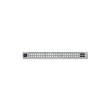 Vista frontal del switch 1U con filas de conectores RJ45, cuatro ranuras SFP+ a la derecha y panel de control con LEDs