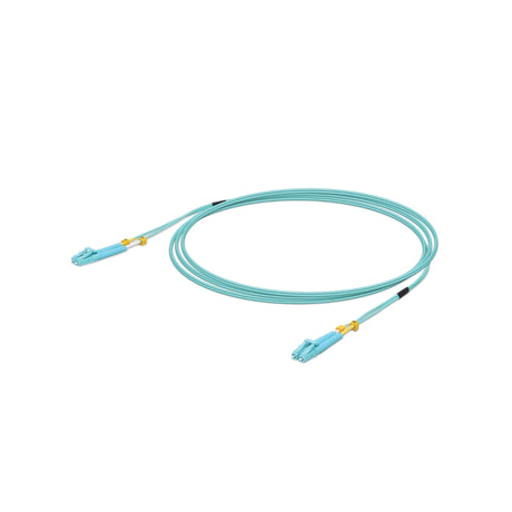 Cable de fibra óptica azul claro OM3 con conectores LC y protectores amarillos enrollado sobre fondo blanco