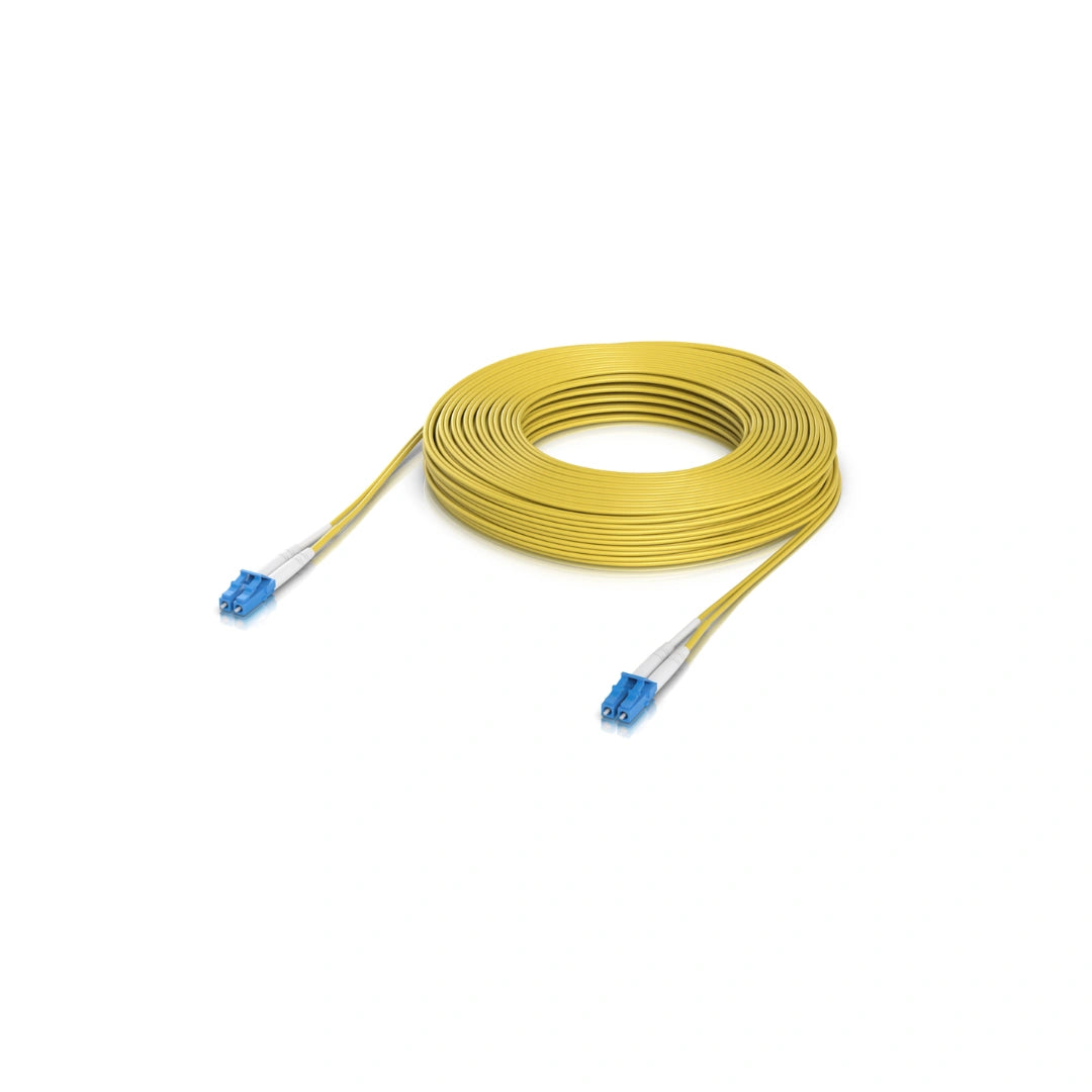 Cable de fibra óptica amarillo enrollado con conectores LC azules y fundas blancas sobre fondo blanco