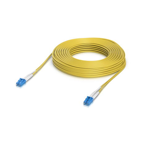 Cable duplex amarillo de fibra óptica con conectores LC azules y fundas blancas, enrollado sobre fondo blanco