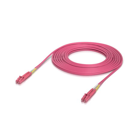 Cable de fibra óptica OM4 rosa enrollado con conectores LC y protección amarilla sobre fondo blanco