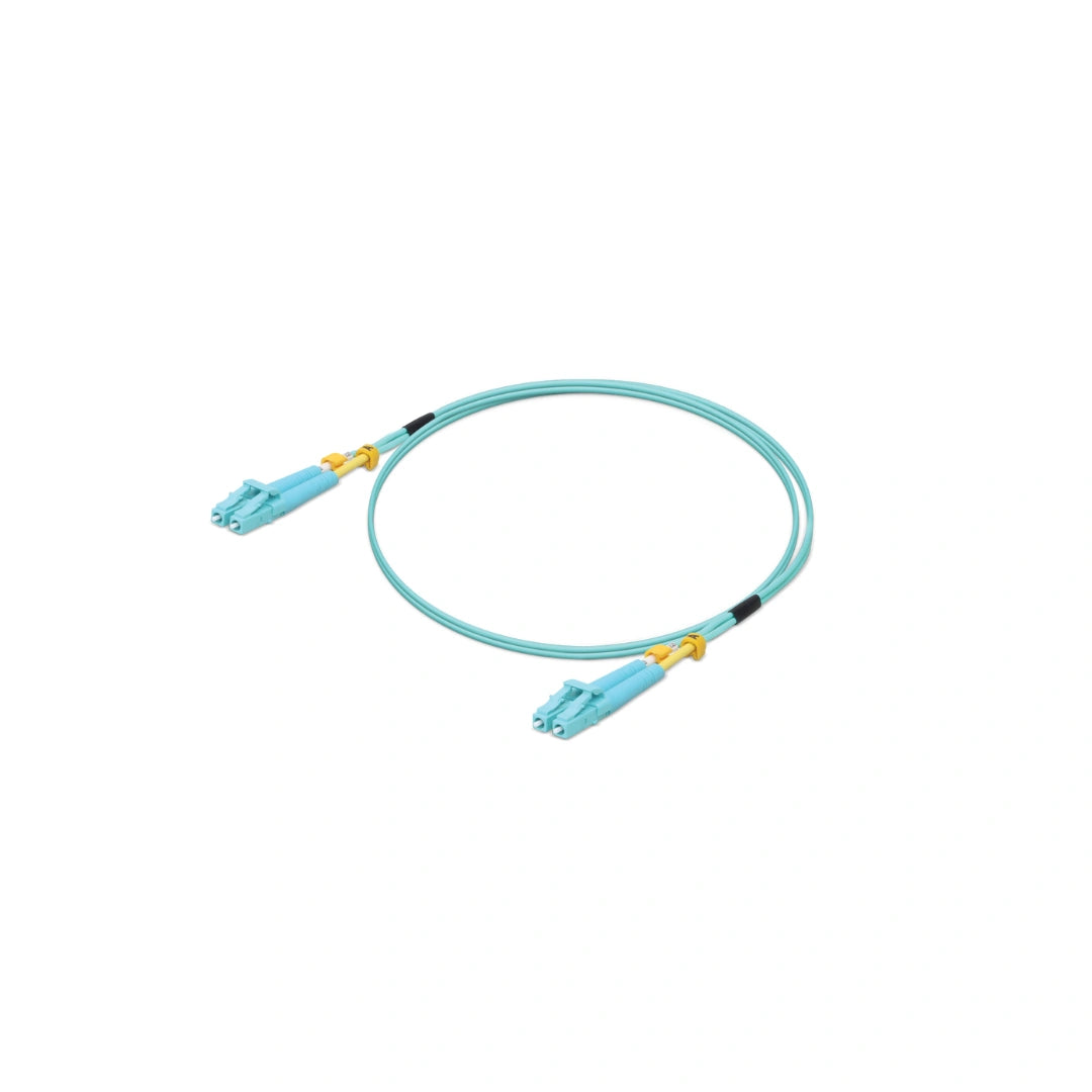 Jumper UniFi azul claro con terminales LC dorados y protectores amarillos sobre fondo blanco