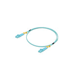 Jumper UniFi azul claro con terminales LC dorados y protectores amarillos sobre fondo blanco