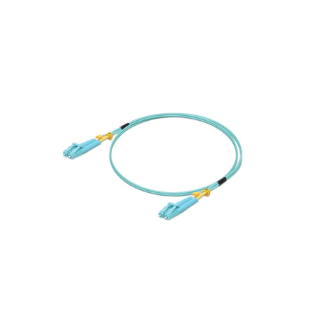 Jumper UniFi azul claro con terminales LC dorados y protectores amarillos sobre fondo blanco