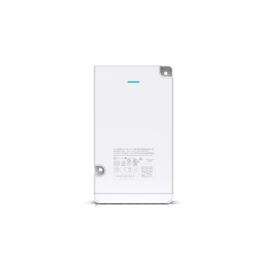 Panel trasero del UniFi AP con texto regulatorio, códigos QR, números de serie e indicador LED azul sobre superficie blanca.