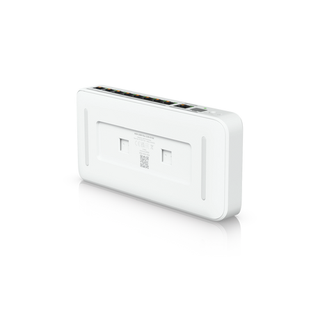 Parte trasera del switch mostrando ranuras para montaje en pared y ventilación