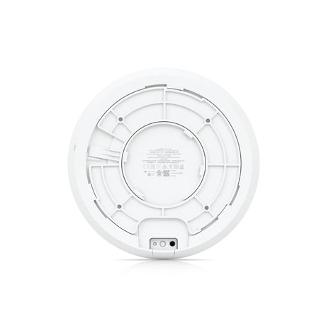 Vista trasera del punto de acceso Ubiquiti UniFi blanco con rejilla de montaje, etiquetas de certificación y puerto inferior.