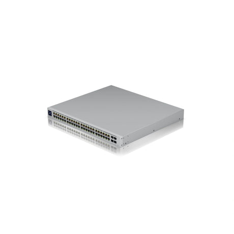 Switch de red Ubiquiti UniFi plateado con densos puertos RJ45 frontales y ranuras SFP+ sobre superficie blanca