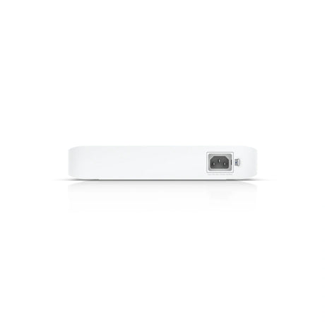Vista trasera enfocada en el conector de alimentación IEC C14 y mecanismo de cierre sobre panel blanco limpio